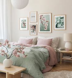 a bedroom with pink and green bedding and pictures on the wall above the bed