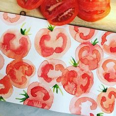 tomatoes on a cutting board next to a piece of paper with the word love painted on it