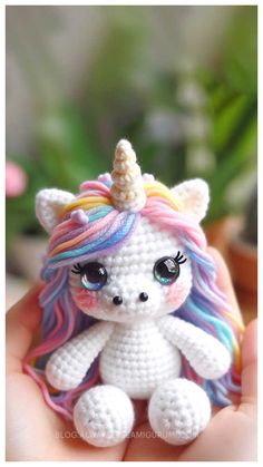 a small crocheted unicorn sitting in someone's hand