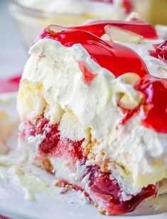 a piece of cake on a plate covered in whipped cream and cherries