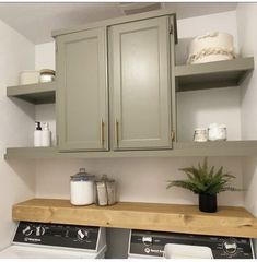 a washer and dryer sitting next to each other in a room with wooden shelves