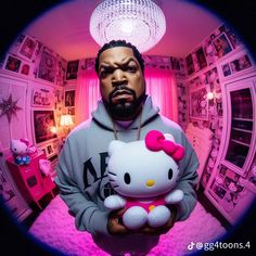 a man holding a hello kitty stuffed animal in his hands while wearing a hoodie