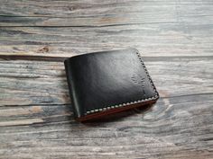 Black color Bifold Wallet is a simple slim design made to carry your essentials. It holds cards in each of its six slots, as well as bills and receipts in the main pocket. This wallet is finished with a saddle stitch, edges burnished, and hand stamped with our logo. Our shop produces and sales handmade wallet, leather wallet, custom wallet, biker wallet, men's wallet, women's wallet and others handcraft leather products. That made from the genuine leather for peraonalized gift, gifts for men, gifts for him, gifts for dad, anniversary gift and birthday gift. Bifold Wallet black color personalized wallet Gift   Ships worldwide from Thailand Made from a high quality natural full grain leather Handmade and Hand stitching  High quality Vegetable tanned leather Handdye Black color outside Natura Black Smooth Grain Wallet As Gift, Black Handmade Trifold Wallet For Daily Use, Handmade Black Trifold Wallet For Everyday Use, Classic Handmade Black Wallet, Classic Black Handmade Wallet, Simple Wallet, Saddle Stitch, Handmade Wallet, Biker Wallet