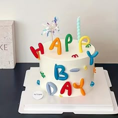 a birthday cake with candles and letters on it