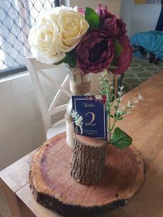 there is a vase with flowers in it on top of a tree stump that has been cut down