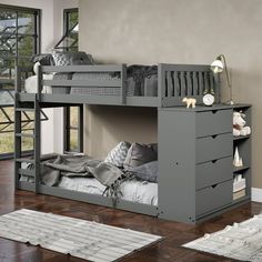 a bunk bed with drawers underneath it in a living room next to a large window