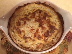 a casserole in a white dish on top of a table with a floral place mat