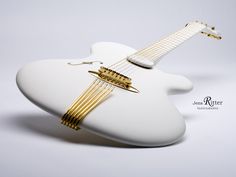 a white guitar with gold strings on it