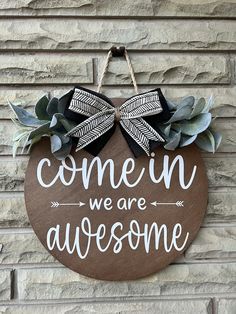 a wooden sign that says, come in we are awesome