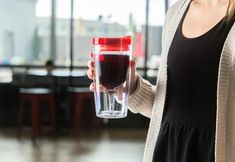 a woman holding a cup with liquid in it