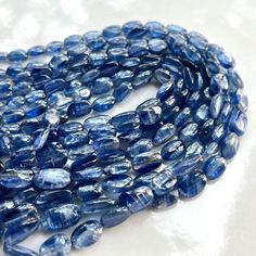 a strand of blue glass beads on a white surface