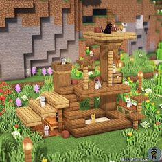 an image of a cat house in the middle of some flowers and grass with cats sitting on it