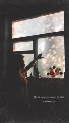 a woman is looking out the window at something