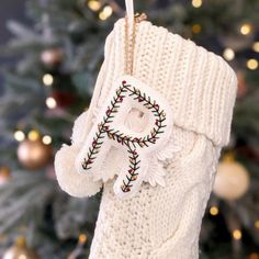 a white stocking hanging from a christmas tree