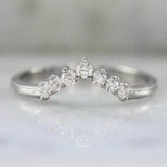 Why I Love It: This delicate tiara band makes a wonderful addition to your stack or on its own. Seven high quality white round brilliant cut diamonds are set into your choice of golds, and is perfect to pair with low profile rings. The Details: Available in: 14k Yellow Gold, 14k White Gold, 14k Rose Gold & 18k Peach Gold Available in 18k & Platinum By Request Approximately .19 Carats of GH/VS White Round Brilliant Cut Diamonds Natural Diamonds Lab Diamonds By Request Band Width is Approx. 1.80 m Dainty White Gold Lab Grown Diamond Wedding Ring, Dainty White Gold Lab-grown Diamond Wedding Ring, Crown Shaped Diamond Wedding Ring With Prong Setting, Delicate White Gold Half Eternity Diamond Ring, Delicate Cubic Zirconia Wedding Ring With Brilliant Cut, Crown-shaped Diamond Ring With Diamond Accents, Crown Shaped Diamond Ring With Diamond Accents, Crown-shaped Diamond Ring With Accents, Crown Shape Diamond Ring With Accents