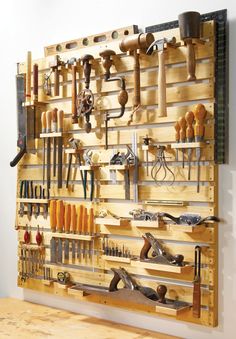 a wall mounted tool rack filled with lots of tools