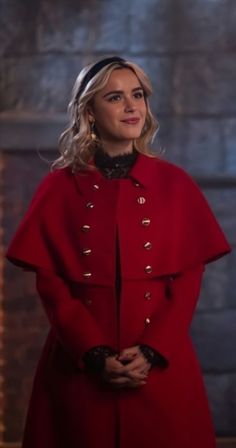 a woman in a red coat is standing