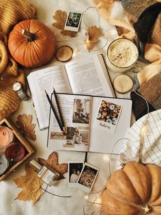 an open book sitting on top of a table next to pumpkins and other items