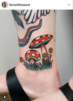 a foot with tattoos on it and some mushrooms