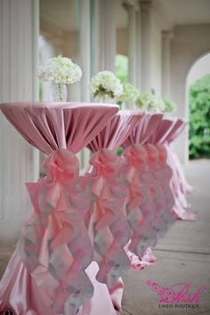 the tables are covered with pink cloths and white flowers