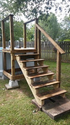 a wooden stair case sitting in the grass