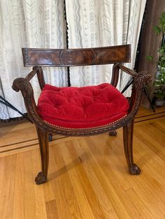 a red chair sitting on top of a hard wood floor