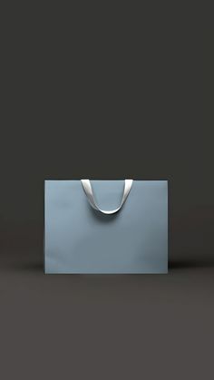 an empty blue bag sitting on top of a gray surface with a silver ring around the handle