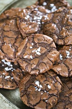 chocolate cookies with white sprinkles are on a glass plate, ready to be eaten