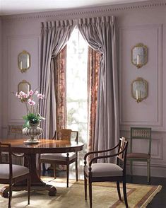 an elegant dining room with pink walls and curtains