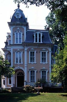 a large yellow house with a clock on it's roof