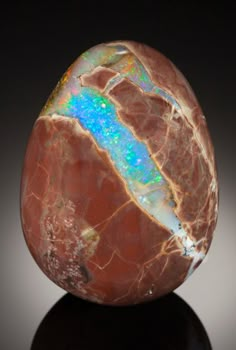 an opalite rock sitting on top of a black surface