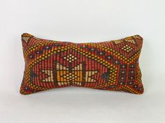 a decorative pillow with an orange, yellow and red design on it's side