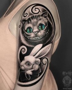 a woman's arm with a cat and rabbit tattoo on it