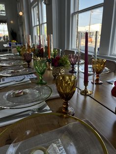 a long table is set with glassware and place settings for four people to sit at