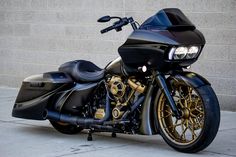 a black and gold motorcycle parked next to a brick wall