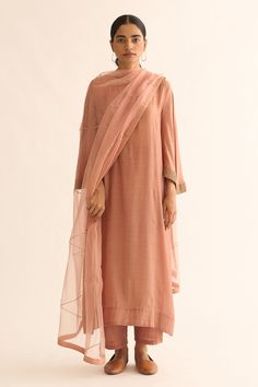 Old rose cotton silk kurta with round neck and bell sleeves with gold zari hand embroidered border. Paired with straight fit pants.
Components: 2
Pattern: Hand Embroidered
Type Of Work: Zari Work
Neckline: Round Neck
Sleeve Type: Bell Sleeves
Fabric: Cotton Silk
Color: Pink
Other Details: 
Keyhole back
Side slits on kurta
Kurta Closure: Back loop button
Note: dupatta worn by the model is not for sale
Occasion: Puja,Work - Aza Fashions Straight Fit Pants, Silk Kurta, Embroidered Border, Old Rose, Zari Work, Kurta With Pants, Fashion Dresses Casual, Indian Fashion Dresses, Simple Trendy Outfits