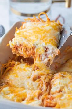 a casserole dish with meat and cheese being lifted from the casserole