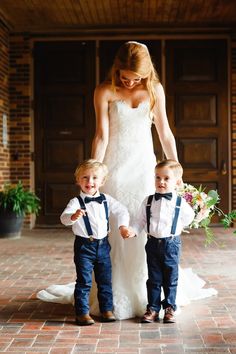 a woman and two young boys standing in front of a building