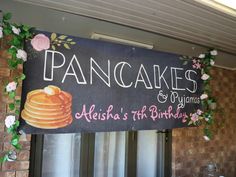 a pancake sign hanging from the side of a brick building