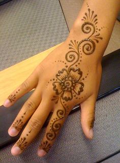 a woman's hand with henna tattoos on it