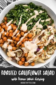 a white bowl filled with vegetables and chickpeas covered in ranch dressing on top of a black and white checkered table cloth