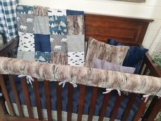 a baby crib with blue and gray bedding in the corner, along with bear themed pillows