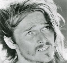 a black and white photo of a man with long hair on top of his head