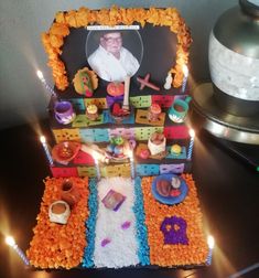 a cake that has been decorated with candles and pictures on the top, sitting on a table