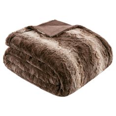 a brown and white blanket on top of a bed