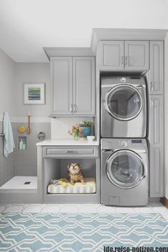 a washer and dryer in a small room with blue rug on the floor