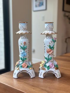 two porcelain vases sitting on top of a wooden table