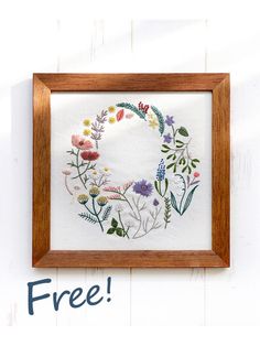 a cross stitch wreath with the words free in front of it and an image of flowers