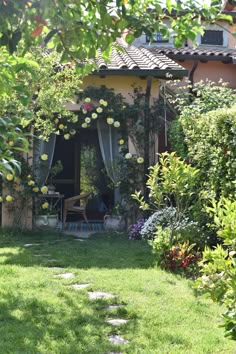 a small house with lots of greenery in the yard