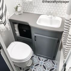 a white toilet sitting next to a sink in a bathroom